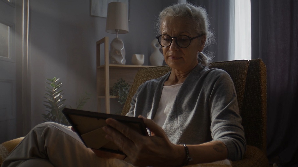 Starija osoba čita dokument pre potpisivanja ugovora o doživotnom izdržavanju