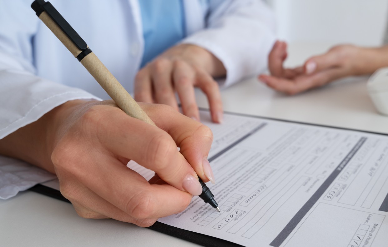 Lekar popunjava lekarsko uverenje tokom zdravstvenog pregleda kandidata za vozačku dozvolu